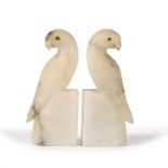 A PAIR OF FRENCH ALABASTER BOOK ENDS in the form of parrots, each with glass eyes, 18cm high