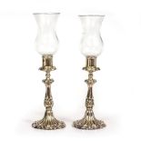 A PAIR OF VICTORIAN SILVER PLATED CANDLESTICKS with glass shades or storm lights with moulded