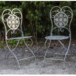 A PAIR OF PAINTED WROUGHT IRON FOLDING GARDEN CHAIRS with pierced foliate decoration, each 42cm wide