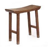 AN ARTS AND CRAFTS OAK STOOL with shaped top and square legs and united by stretchers at each end,