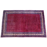 AN ARAAK RED GROUND RUG with dense pattern central field within a multiple banded border, 330 x