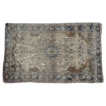 A CREAM GROUND KASHAN RUG with floral decorations to the central field and within a triple banded