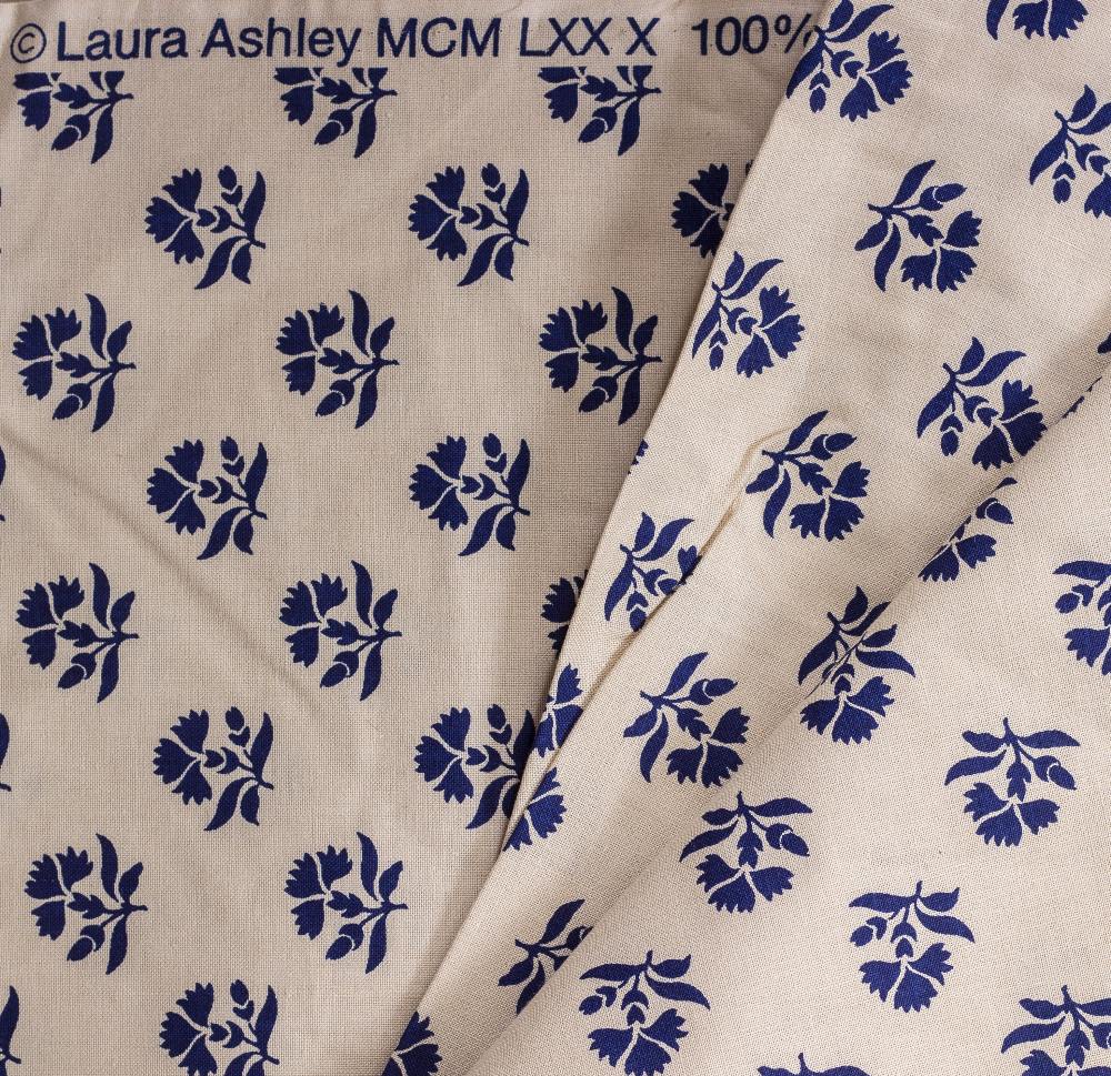 THREE ROLLS OF LAURA ASHLEY CREAM GROUND MATERIAL decorated with blue flowers together with a