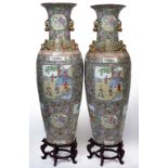 A PAIR OF ORIENTAL FAMILLE VERTE FLOOR VASES decorated with figures on a terrace applied with gilt