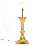 AN ORMOLU TABLE LAMP with flaring octagonal stem and scrolling tripod base, 64cm high to the top