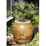 A LARGE ORIENTAL STONE WARE OVOID PLANTER decorated with a dragon and complete with small palm,