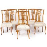 A SET OF TWELVE CONTINENTAL BEECHWOOD DINING CHAIRS with pierced splats, overstuffed upholstered