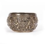 AN ANTIQUE EASTERN POSSIBLY BURMESE WHITE METAL BOWL with embossed figural decoration, 11cm diameter