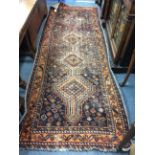 A MIDDLE EASTERN RED AND ORANGE GROUND RUG with a banded border and geometric decoration, 101cm x