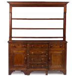 A VICTORIAN OAK AND MAHOGANY WELSH DRESSER with a plate rack above six drawers and two cupboards,