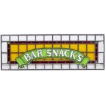 A 20TH CENTURY LEADED STAINED GLASS PANEL 'BAR SNACKS' 126cm wide x 44cm high Condition: several