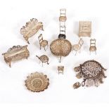 A GROUP OF FILIGREE WHITE METAL MINIATURE FURNITURE to include a pair of settees, a dining table,