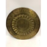 AN INDIAN ENGRAVED BRASS TRAY with flower decoration in cartouches containing figures, 76cm diameter