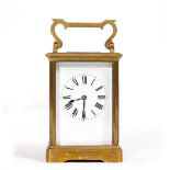 A BRASS CARRIAGE CLOCK, with enamel dial, striking the hours and half hours in a gong, 17cm high
