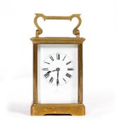 A BRASS CARRIAGE CLOCK, with enamel dial, striking the hours and half hours in a gong, 17cm high