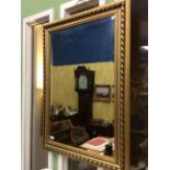 A CONTEMPORARY GILDED PINE FRAMED RECTANGULAR WALL MIRROR with bevelled glass, 76.5cm x 106cm