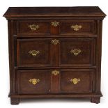 A 17TH CENTURY OAK CHEST OF THREE LONG DRAWERS with brass handles and raised on stile feet, 87cm