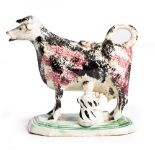 AN 18TH CENTURY PEARLWARE/PRATT WARE COW CREAMER with sponged decoration and octagonal base, 13cm