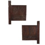 A PAIR OF ANTIQUE CARVED OAK CUPBOARD DOORS each of panelled construction and hinged to original
