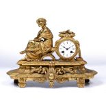 A LATE 19TH CENTURY GILT SPELTER MANTEL CLOCK in the form of a classical maiden seated holding a
