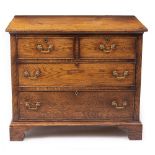 A 20TH CENTURY OAK CHEST OF TWO SHORT AND TWO LONG DRAWERS with brass swan neck handles and