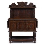 AN ANTIQUE AND LATER OAK SIDE CABINET of carved panel construction, with a raised back, barley twist