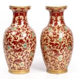 A PAIR OF MODERN ORIENTAL PORCELAIN VASES of baluster form with red ground and scrolling gilt