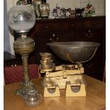 A SET OF AVERY SCALES and a spelter oil lamp with a glass shade and a wall clock At present, there