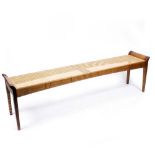 A MODERN ASH AND CANED WINDOW SEAT standing on square tapering legs, 182cm wide x 35.5cm deep x 50.