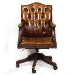 A BROWN LEATHER BUTTON UPHOLSTERED DESK CHAIR in the Georgian style, rotating mechanism and splaying