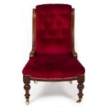 A VICTORIAN WALNUT FRAMED UPHOLSTERED LOW CHAIR with turned front legs and brass and ceramic