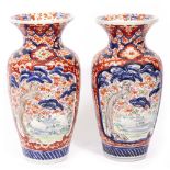 A PAIR OF ORIENTAL VASES with flaring rims, decorated in Imari colours and with moulded scenes of