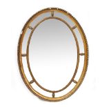 A GILT OVAL WALL MIRROR with central bevelled mirror plate, 64.5cm wide x 85cm high Condition: the