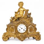A 19TH CENTURY FRENCH GILT METAL MANTLE CLOCK adorned with a cherub, the enamelled dial signed '