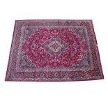 A MIDDLE EASTERN MASHAD HAND KNOTTED WOOLLEN CARPET with classic floral decoration and a central