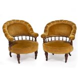 A PAIR OF LATE VICTORIAN WALNUT FRAMED UPHOLSTERED TUB CHAIRS with turned legs terminating in