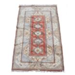 A TURKISH RED AND CREAM GROUND RUG with geometric decoration, 156cm x 260cm Condition: some wear and