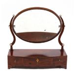 A 19TH CENTURY MAHOGANY BOW FRONTED DRESSING TABLE MIRROR with oval mirror plate, the base with