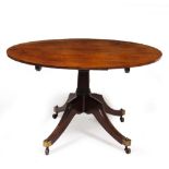 A 19TH CENTURY MAHOGANY TILT TOP BREAKFAST TABLE with turned stem, four sabre legs and brass