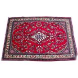 A MIDDLE EASTERN HAMADAN RED GROUND CARPET with a floral decoration, a central medallion and ivory