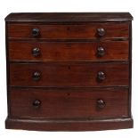 A 19TH CENTURY MAHOGANY BOW FRONTED CHEST OF FOUR LONG DRAWERS with turned knob handles and plinth