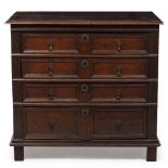 A 17TH CENTURY OAK CHEST OF FOUR LONG DRAWERS of pegged construction with panelled sides, feet later