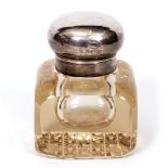 AN EARLY 20TH CENTURY HEAVY GLASS AND SILVER TOPPED INKWELL with marks for London 1904, 10cm