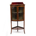 AN EDWARDIAN BOW FRONTED CORNER DISPLAY CABINET with raised back, twin glazed doors and square