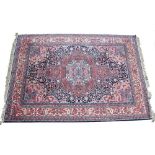 AN AMERICAN MADE PERSIAN STYLE SMALL CARPET with styalised foliate decoration and a banded border,