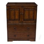 A MID TO LATE 20TH CENTURY OAK CABINET with linen fold cupboard doors over two drawers, 78cm wide