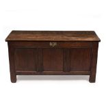 AN 18TH CENTURY OAK CHEST OR COFFER with panelled front, back and sides and standing on stile