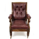 A LATE 19TH CENTURY GOTHIC STYLE OAK FRAMED LIBRARY ARMCHAIR with leather upholstery, scrolling