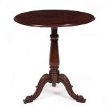 A WILLIAM IV MAHOGANY TILT TOP TRIPOD TABLE with a turned stem, carved scrolling legs, the single