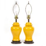 A PAIR OF MODERN TABLE LAMPS with yellow ground porcelain bodies, on circular plinths, 46cm high